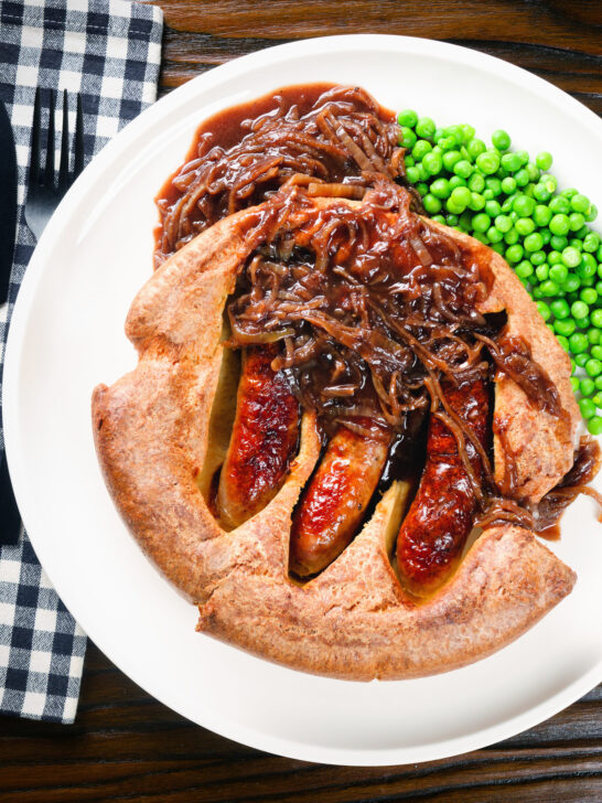 Overhead individual toad in the hole served with peas and a rich onion gravy.