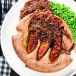 Overhead individual toad in the hole served with peas and a rich onion gravy.