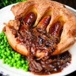 Individual toad in the hole served with peas and a rich onion gravy.