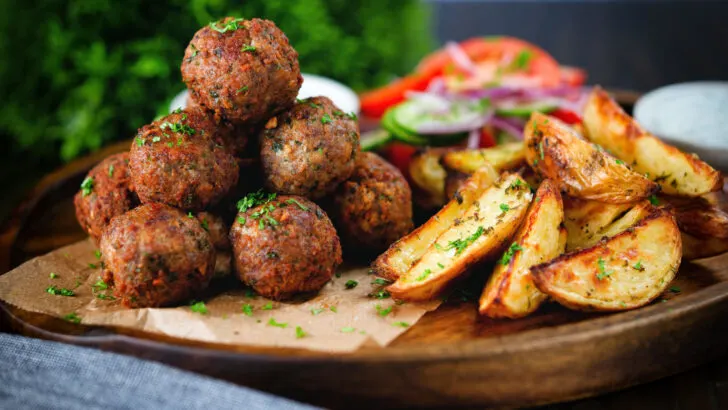 Greek meatballs or keftedes served with a yoghurt dip and lemony potato wedges.