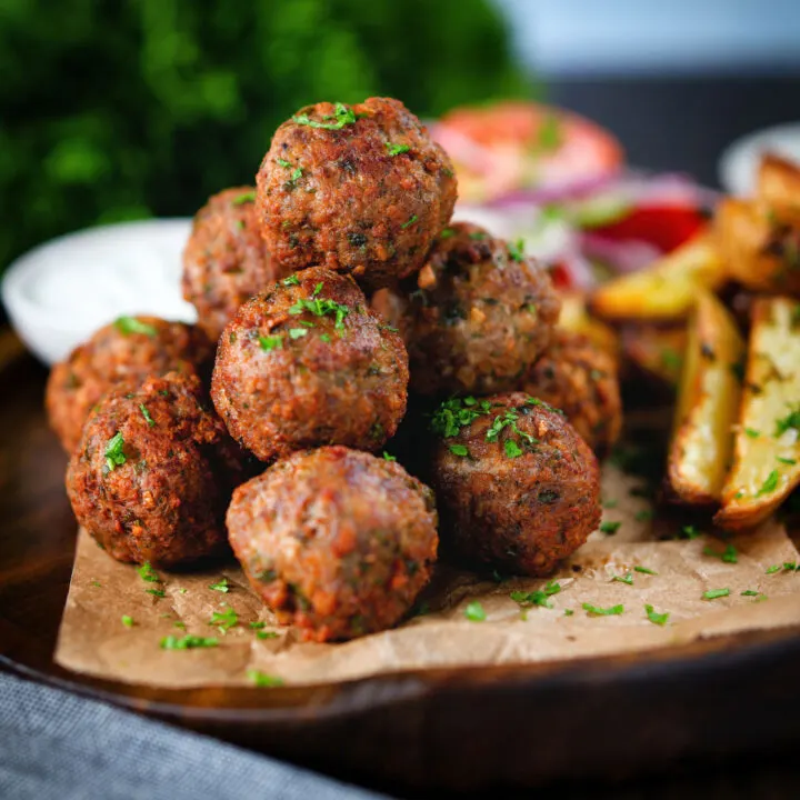 Greek meatballs or keftedes served with a yoghurt dip and lemony potato wedges.