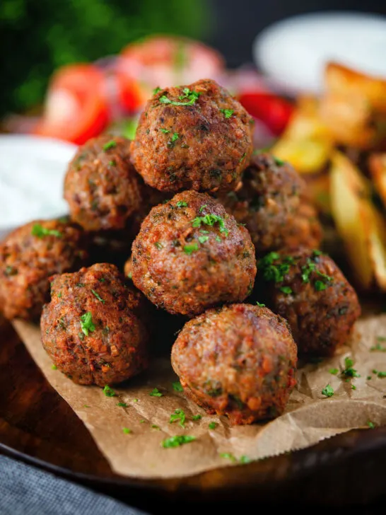 Greek meatballs, keftedes served with a yoghurt dip, salad and potato wedges.