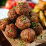 Greek meatballs, keftedes served with a yoghurt dip, salad and potato wedges.