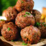 Close up fried Greek meatballs or keftedes garnished with parsley.