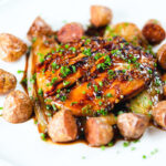 Maple syrup and Worcestershire sauce glazed chicken breast with fried potatoes and braised chicory.