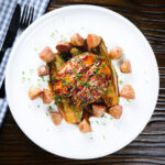 Maple syrup glazed chicken breast with fried potatoes and braised chicory.