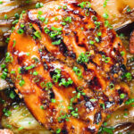 Close-up overhead maple syrup and Worcestershire sauce glazed chicken breast with fried potatoes and braised chicory.