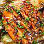 Close-up overhead maple syrup and Worcestershire sauce glazed chicken breast with fried potatoes and braised chicory.