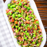 Overhead minted pea salsa or salad with capers, tomatoes chilli and red onion.
