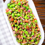 Overhead minted pea salsa or salad with capers, tomatoes chilli and red onion.