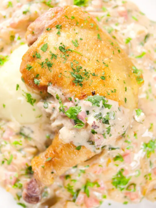 Overhead close-up chicken Normandy in a cider and mustard sauce served with creamy mashed potatoes.