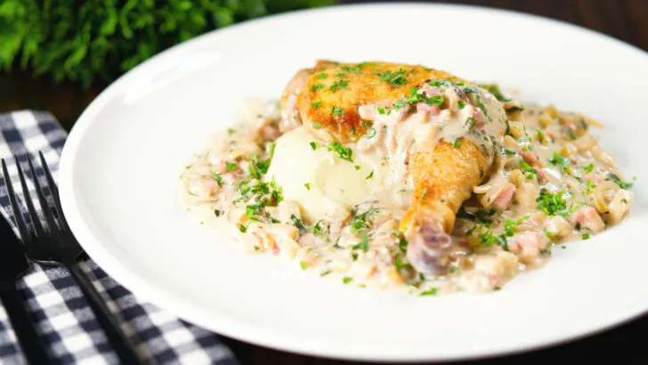 Normandy style chicken legs with a creamy cider sauce and mashed potato garnished with parsley.