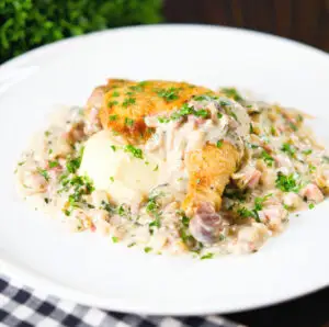 Normandy style chicken legs with a creamy cider sauce and mashed potato garnished with parsley.