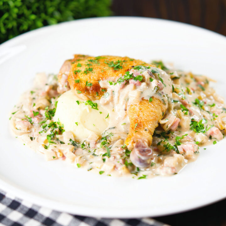 Normandy style chicken legs with a creamy cider sauce and mashed potato garnished with parsley.