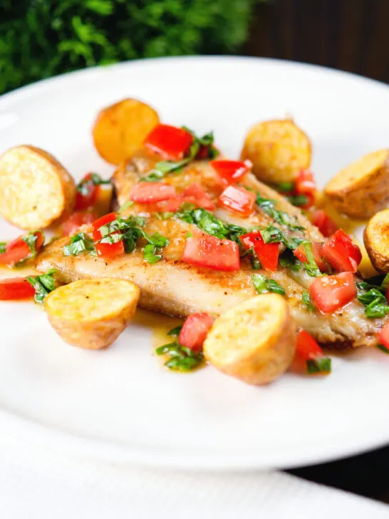 Pan fried brill fish served with sauce vierge and fried potatoes.