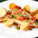 Pan fried brill fish served with sauce vierge and fried potatoes.