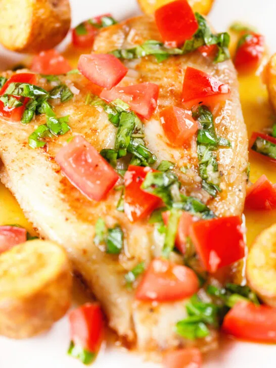 Close-up pan fried brill fish served with sauce vierge and fried potatoes.
