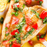 Close-up overhead pan fried brill fish served with sauce vierge and fried potatoes.