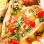 Close-up overhead pan fried brill fish served with sauce vierge and fried potatoes.