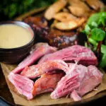 Roast ham hock meat served with potato wedges and cider sauce.