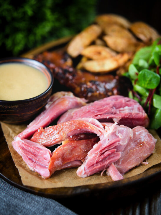 Roast ham hock meat served with potato wedges and cider sauce.