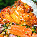 Close up tandoori cod fish with raita and a mung bean salad.