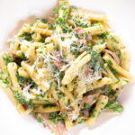 Overhead close-up spinach and mushroom pasta with parmesan cheese.