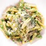 Overhead close-up spinach and mushroom pasta with parmesan cheese.