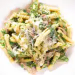 Overhead close-up spinach and mushroom pasta with parmesan cheese.