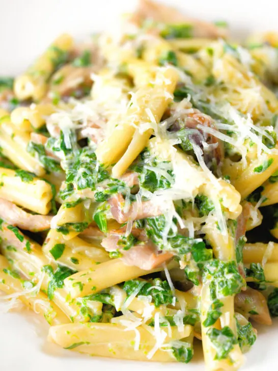 Close-up spinach and mushroom casarecce pasta with parmesan cheese.