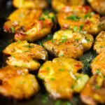 Crispy roasted crushed (smashed) new potatoes garnished with parsley.