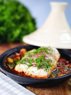 Cod fish tagine with preserved lemons, harissa and sumac in a traditional pot.