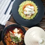 Overhead flaked cod fish tagine served with buttered herby couscous.