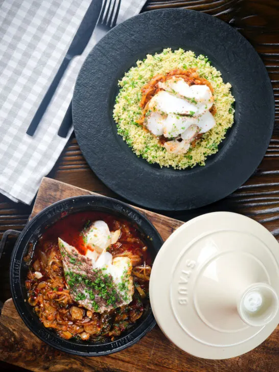 Overhead flaked cod fish tagine served with buttered herby couscous.