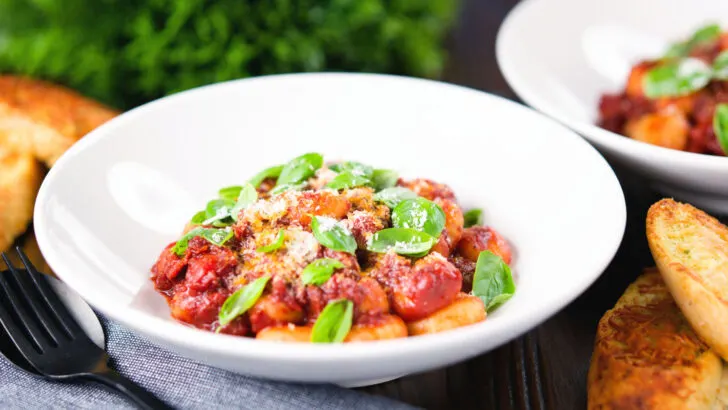 Potato gnocchi with a rich red wine and tomato sauce garnished with basil and Parmesan cheese.