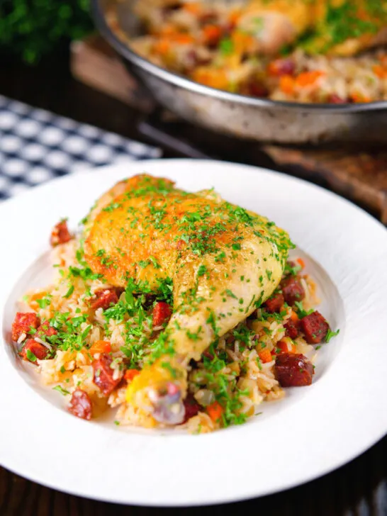 Spanish-influenced baked chicken and chorizo rice served on a plate.
