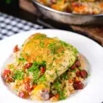 Spanish-influenced baked chicken and chorizo rice served on a plate.
