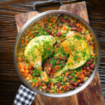 One-pot baked chicken leg and chorizo rice garnished with fresh parsley.