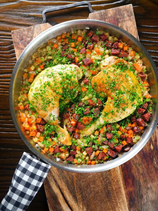 Overhead Spanish-influenced baked chicken and chorizo rice in a cooking pan.