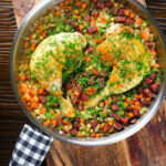 Overhead Spanish-influenced baked chicken and chorizo rice in a cooking pan.