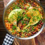 Overhead Spanish-influenced baked chicken and chorizo rice in a cooking pan.
