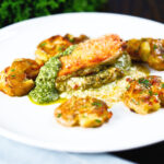 Baked pesto and mozzarella stuffed chicken breast with roasted crushed new potatoes.