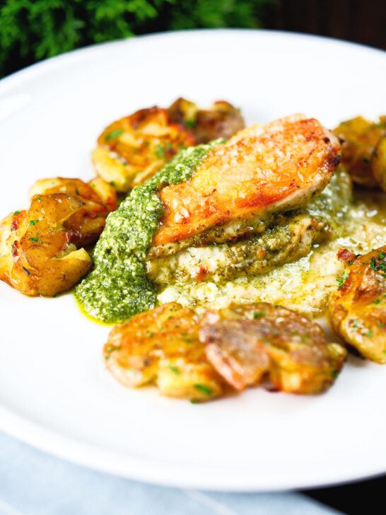 Baked pesto and mozzarella stuffed chicken breast with crushed roasted new potatoes.