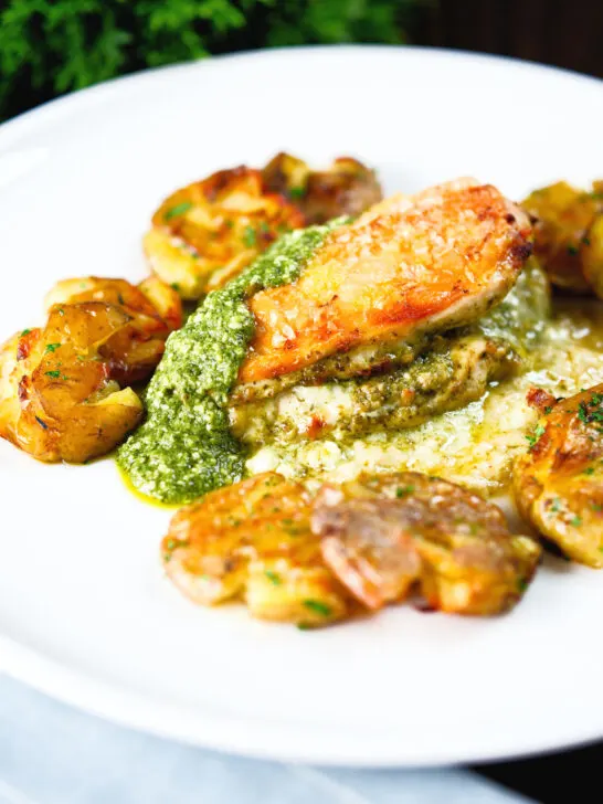 Baked pesto and mozzarella stuffed chicken breast with crushed roasted new potatoes.