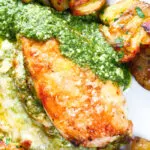 Overhead close-up baked pesto and mozzarella stuffed chicken breast with crispy crushed potatoes.
