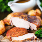 Carved slow cooker pork loin, cider gravy, roast potatoes and green vegetables.