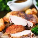 Carved slow cooker pork loin, cider gravy, roast potatoes and green vegetables.