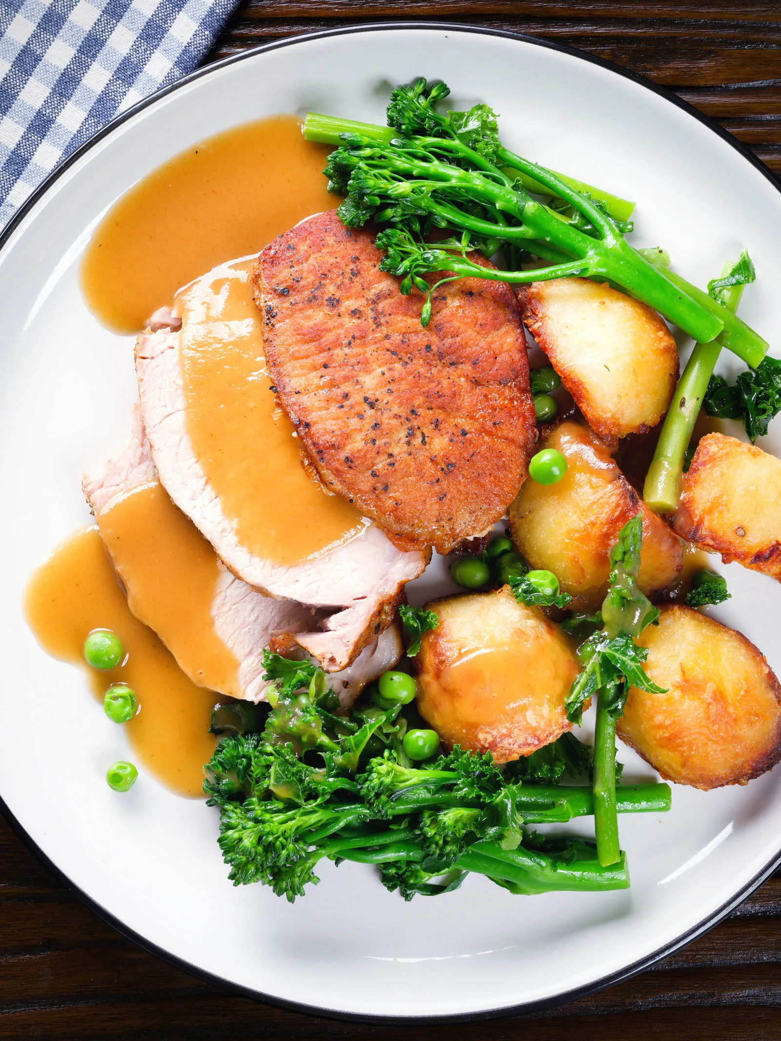 Slow cooker pork loin served with roast potatoes, vegetables and a cider, mustard and honey gravy.