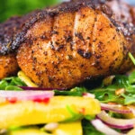 Close-up pan-fried Cajun Blackened cod fish served with mango salad.