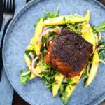 Overhead pan-fried Cajon Blackened cod fish served with mango salad.